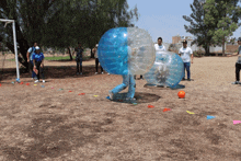 a group of people are playing a game of bubble soccer