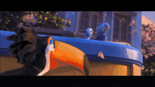 a toucan and a blue bird are standing on top of a building