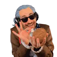 a man wearing headphones and sunglasses holds a coconut in his hands