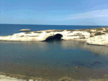 a large body of water surrounded by rocks and a small island