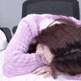 a woman in a purple sweater is laying down