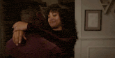 a man and a woman are hugging and smiling in a room