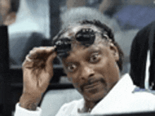 snoop dogg is wearing sunglasses and making a funny face .