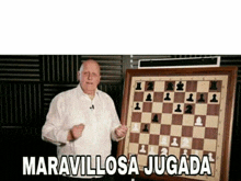 a man standing next to a chess board that says maravillosa jugada on it