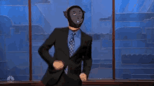 a man in a suit and tie is wearing a monkey mask and dancing