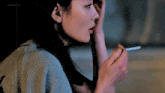 a woman is smoking a cigarette with a watermark that says jngngeoon
