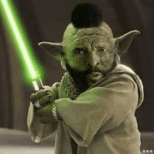 a man with a beard and a mohawk is holding a green lightsaber .