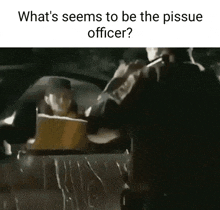 what 's seems to be the pisse officer ? a man is sitting in a car holding a box .