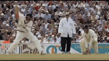 a cricket game is being played in front of a crowd with a sign that says ' on ' on it