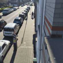 a row of cars parked on the side of a street with a parking meter that says ' parking ' on it