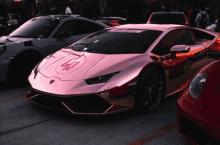 a pink lamborghini is parked next to a silver car