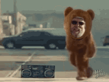 a man in a teddy bear costume is running in front of a boombox with jub jab written on it