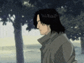 a man with long black hair is standing in front of a tree