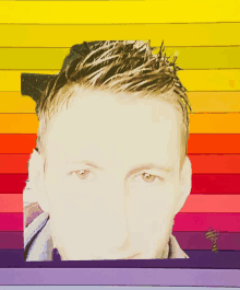 a close up of a man 's face against a rainbow background