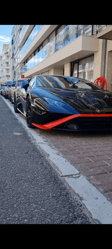 a row of sports cars parked on the side of a street