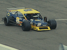 a blue and yellow race car with the number 8 on the front