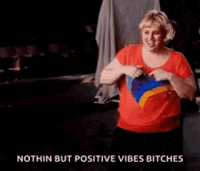 a woman in a red shirt is dancing with a rainbow heart on her shirt .