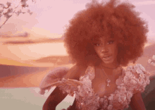 a woman in a pink dress with flowers on the sleeves