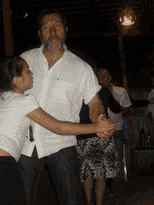 a man in a white shirt is dancing with a girl in a black skirt