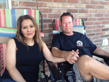 a man and a woman are sitting in lawn chairs and the man is wearing a shirt that says ' texas '