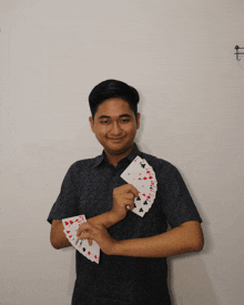 a man is holding a fan of playing cards in his hands