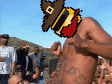 a man without a shirt is standing in front of a crowd of people with a pixelated pilgrim on his head .