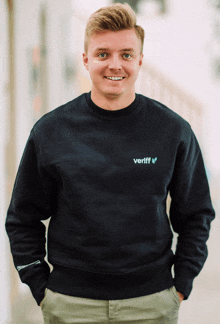 a man wearing a black sweatshirt that says veriff