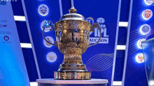 a trophy is sitting in front of a banner that says ipl auction