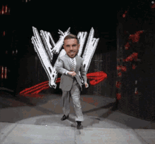 a man in a suit and tie is dancing on a stage in front of a w logo