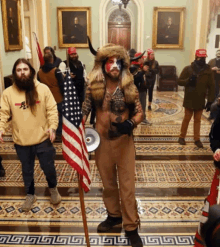 a man dressed as a bull holds an american flag