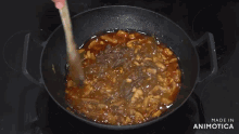 a man is stirring a pot of food in a kitchen with the words made in animatica on the bottom