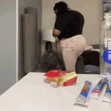 a bottle of aquafina water sits on a table next to some snacks