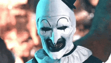 a close up of a clown wearing a mask and top hat .