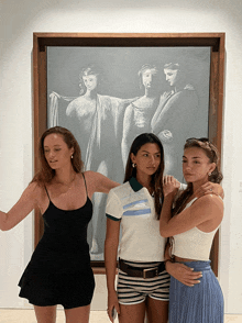 three women are posing in front of a painting of naked women