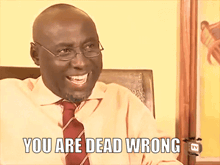 a man with glasses and a tie is smiling and says " you are dead wrong "