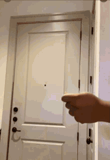 a person 's hand is pointing at a door