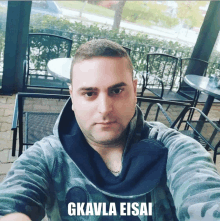 a man taking a selfie with the words gkavla eisai above him