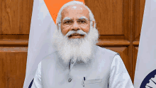 a man with a beard wearing glasses and a grey vest