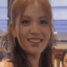 a close up of a woman 's face smiling with a blurry background .