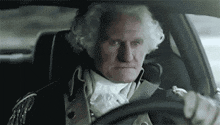 a man dressed as george washington is driving a car in a pixelated image .