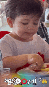 a young boy is playing with a spoon and a bowl of food with the letters o and n on it