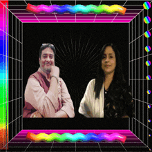 a man and a woman are standing in front of a rainbow colored background