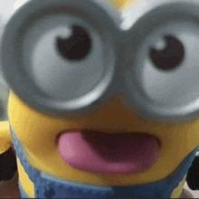 a close up of a minion with a pink tongue sticking out