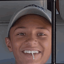 a young boy wearing a hat that says ' boston ' on it smiles