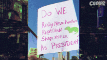 a sign that reads do we really need another reptilian shape shifter as president