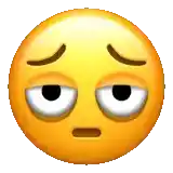a yellow smiley face with a tired look on its face