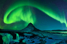 the aurora borealis is displayed over a mountain