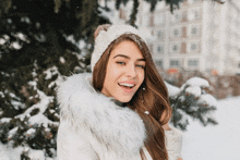 a woman wearing a white hat and a white coat with a fur collar