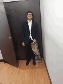 a man in a suit is standing in a hallway