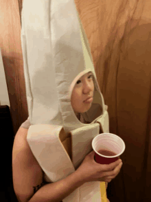 a person wearing a banana costume is holding a cup